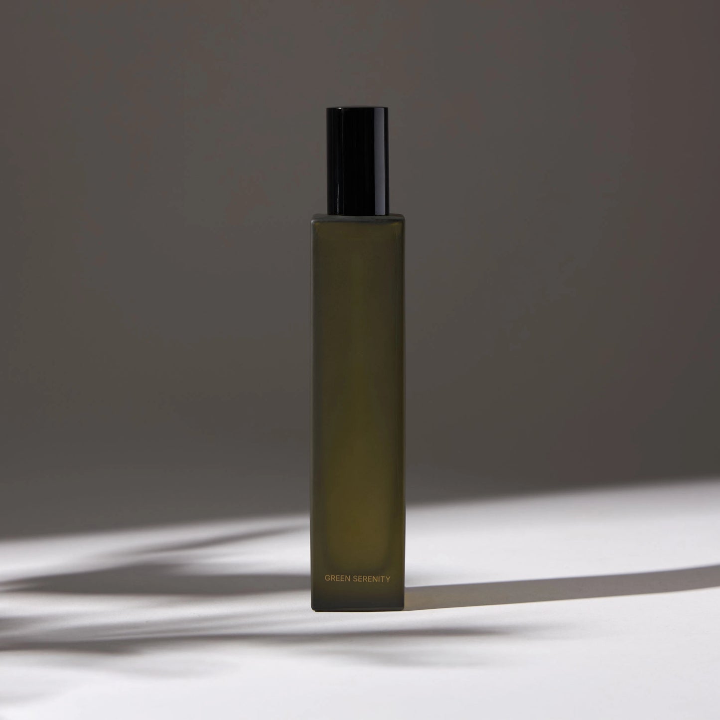 Voucler room spray bottle in dark green with a black cap, highlighting the minimalist packaging on a neutral background.