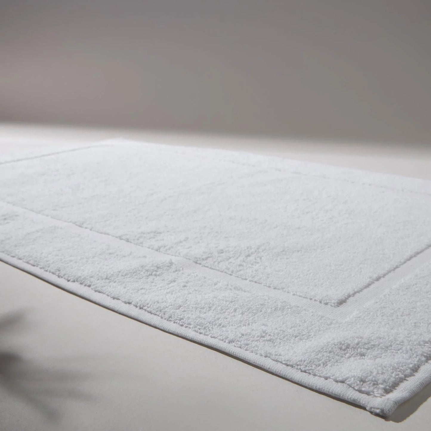 Detailed image of a clean and soft white rug, ideal for bathrooms, conveying a feeling of cleanliness and care for hygiene.