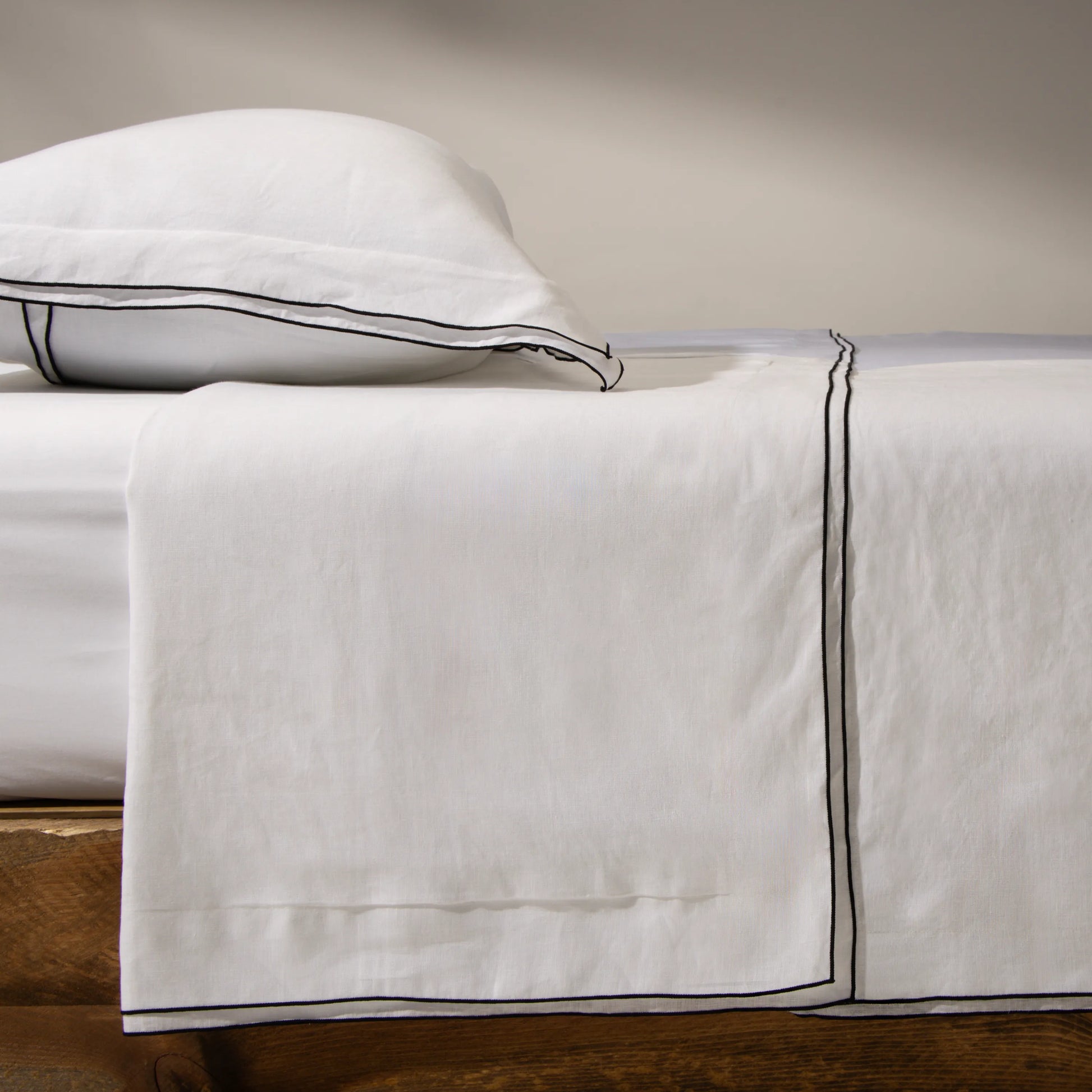 Capa de travesseiro e lençol de cama na cor branca e borda preta