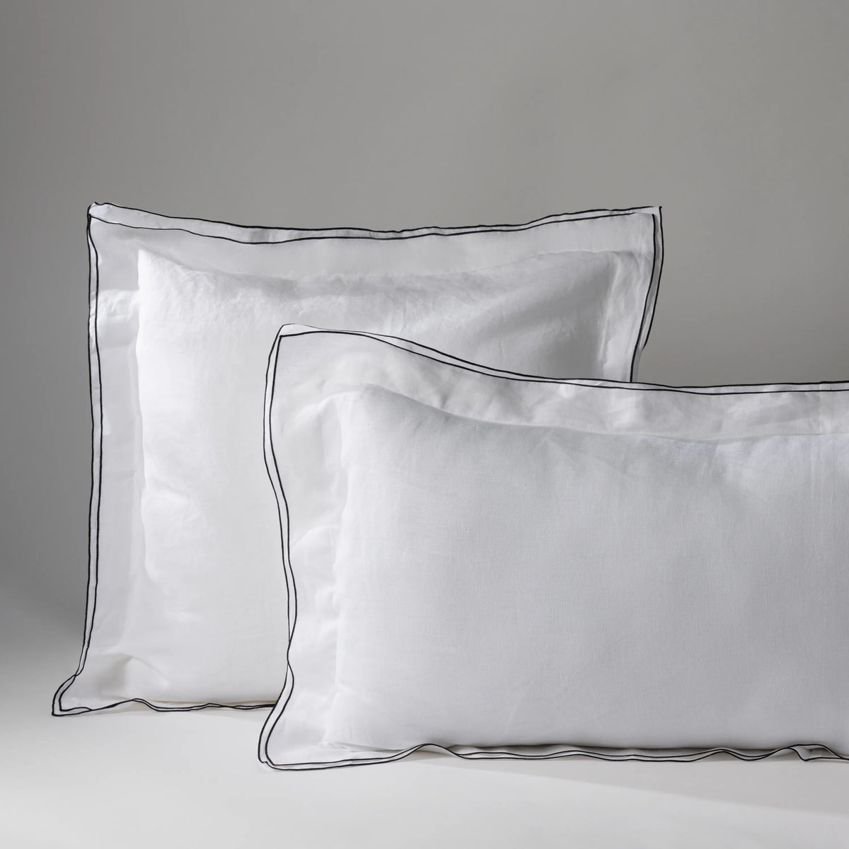 Travesseiro com capa branca e borda preta