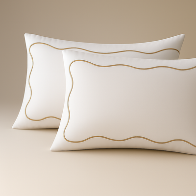 Set of two white pillowcases with elegant golden embroidery, ideal for decorating rooms with a sophisticated and comfortable style.