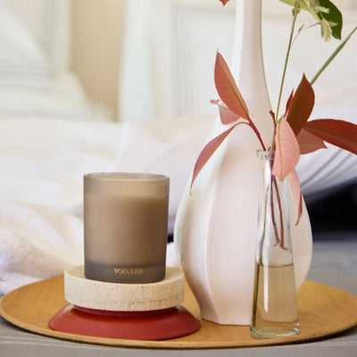 A tray displays a vase containing a candle and a potted plant, enhancing the decor with a touch of nature.