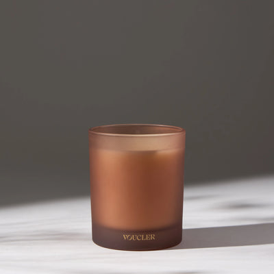 Decorative candle placed on a white surface.