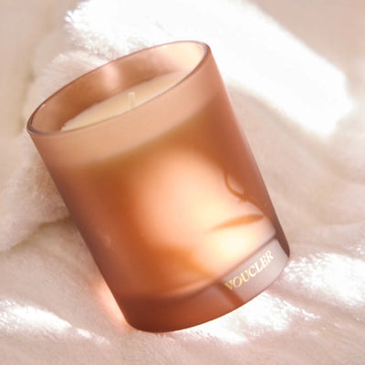 A decorative candle on a white towel, suggesting comfort and calm.