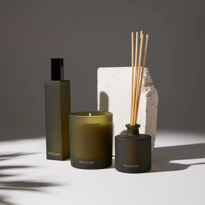 A set of Voucler aromatic products with a candle, diffuser and spray, in a minimalist and elegant setting for home decoration.