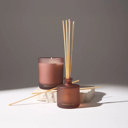 Voucler brand aroma diffuser with scented candle in dark pink frosted glass, decorating a space with an elegant and sophisticated touch.