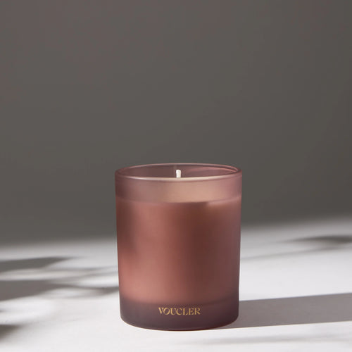 Decorative candle in pink by VOUCLER, with an elegant design, on a light background with soft shadows around it, ideal for decorating rooms.