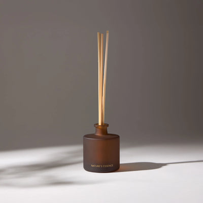 Brown glass aroma diffuser with wooden sticks, ideal for decorating and creating fragrant environments at home or in the office.