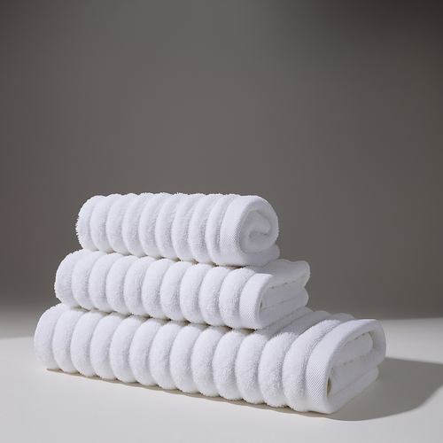 Set of soft white towels stacked in a clean and comfortable environment.