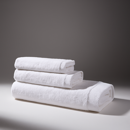 Set of folded and stacked white towels on a surface, the background of the environment is gray, conveying elegance.