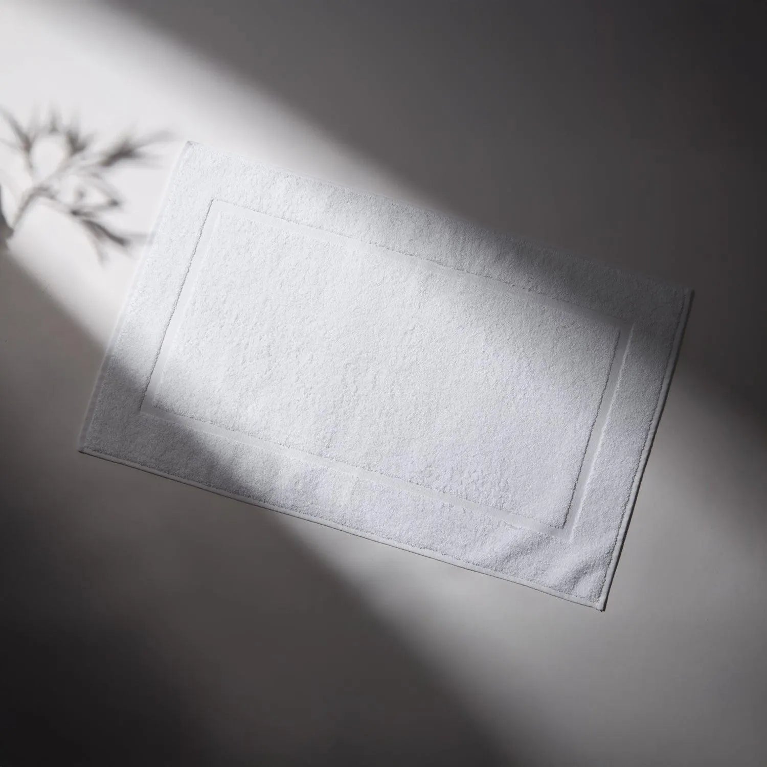 Clean and soft white rug, ideal for bathrooms, conveying a feeling of cleanliness and care for hygiene.