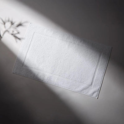 Clean and soft white rug, ideal for bathrooms, conveying a feeling of cleanliness and care for hygiene.