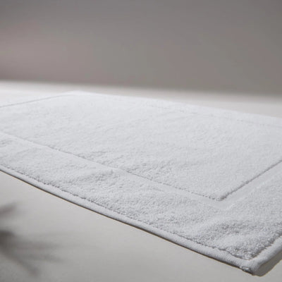 Detailed image of a clean and soft white rug, ideal for bathrooms, conveying a feeling of cleanliness and care for hygiene.