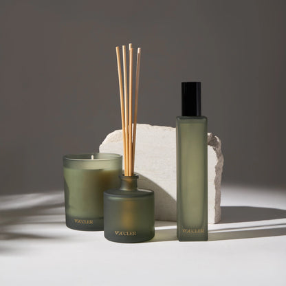 Set of scented candles, aroma diffusers and spray in a frosted green glass container with an elegant and modern design.